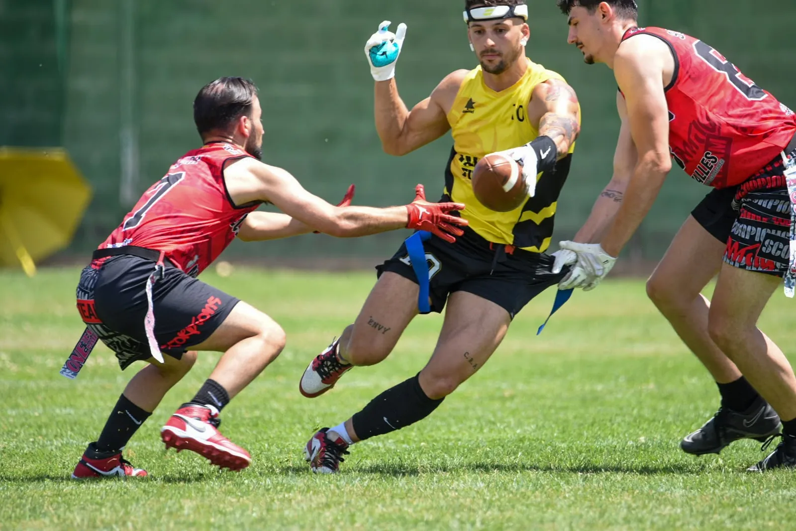 Jugadores de flag football en España durante un partido, con un defensor arrancando la flag