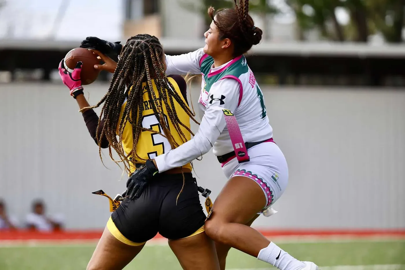 Jugadoras de flag football en una jugada defensiva